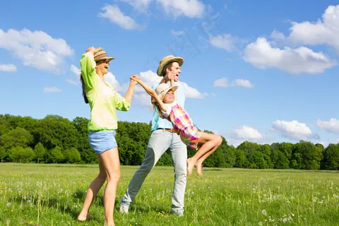 草地上开心跳跃的一家人图片 草地上开心跳跃的一家人图片