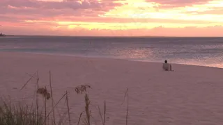 黄色和红色的日落在波光粼粼的海洋沙...