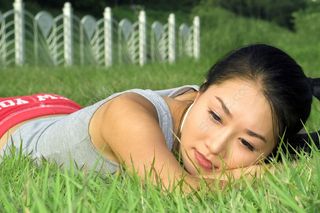 趴在草地上休息的健身美女图片