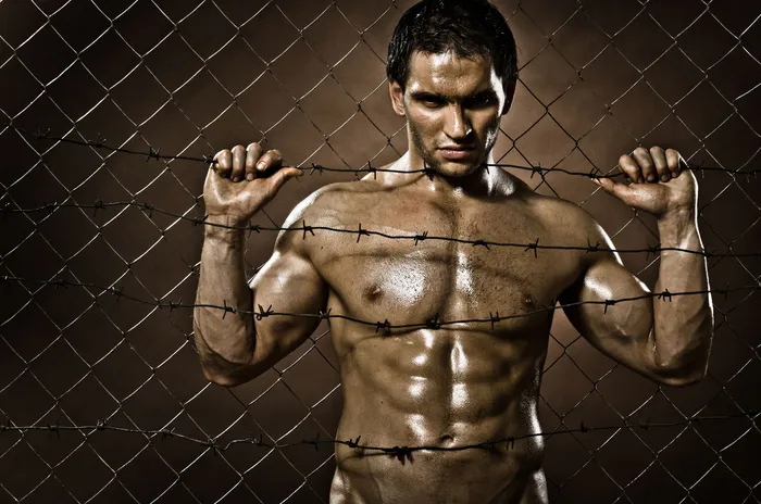 抓住铁网的健身男人