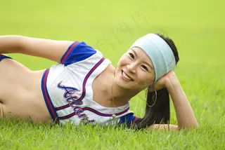 侧躺在草地上休息的健身美女图片