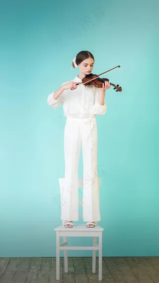 站在椅子上拉小提琴的外国美女高清摄影图片