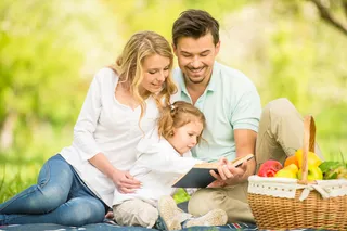 草坪上看书的幸福家庭图片