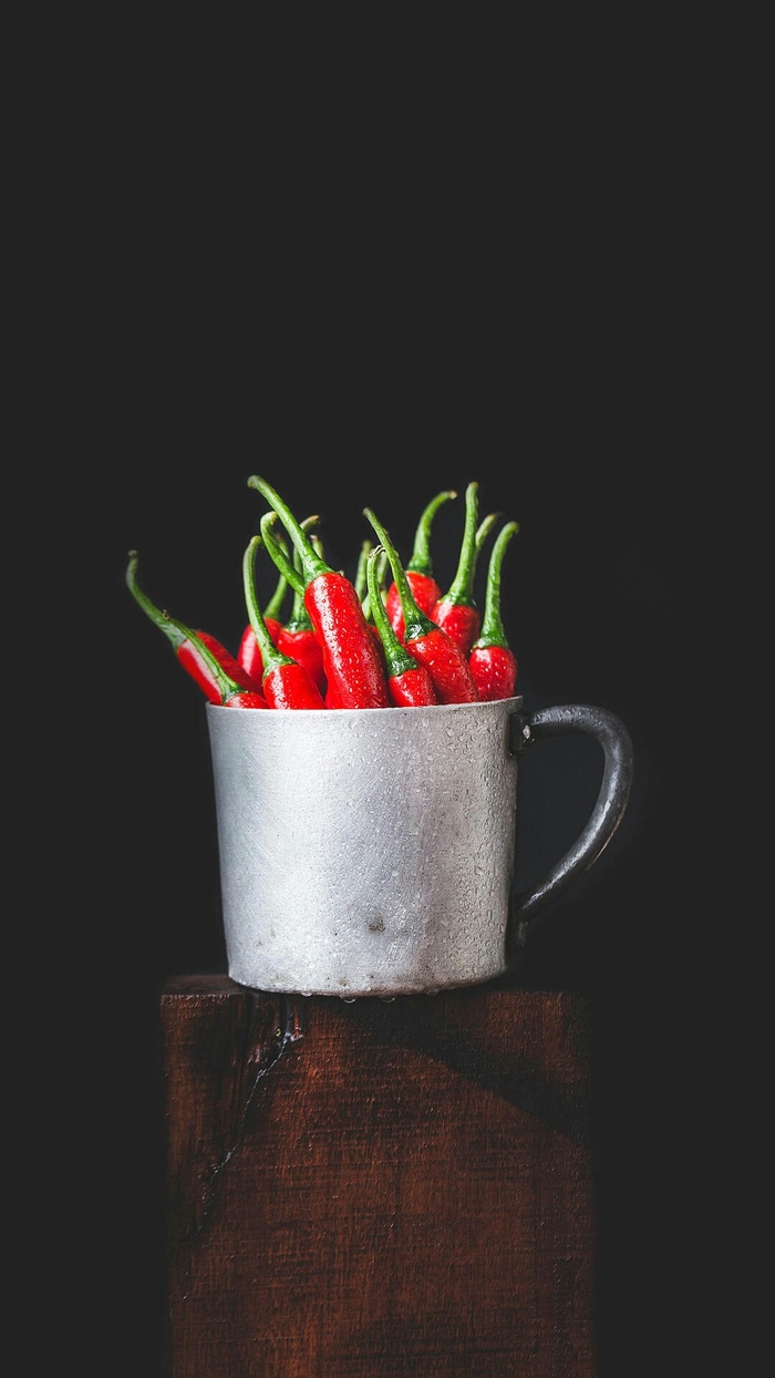 暗色调背景水杯装着的辣椒高清摄影图片