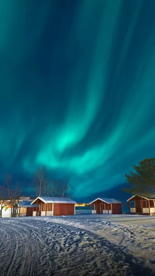 极光下被雪覆盖的房屋高清摄影图片