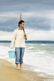 海边捕鱼的男人图片