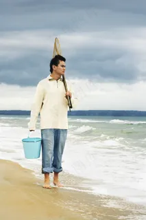 海边捕鱼的男人图片