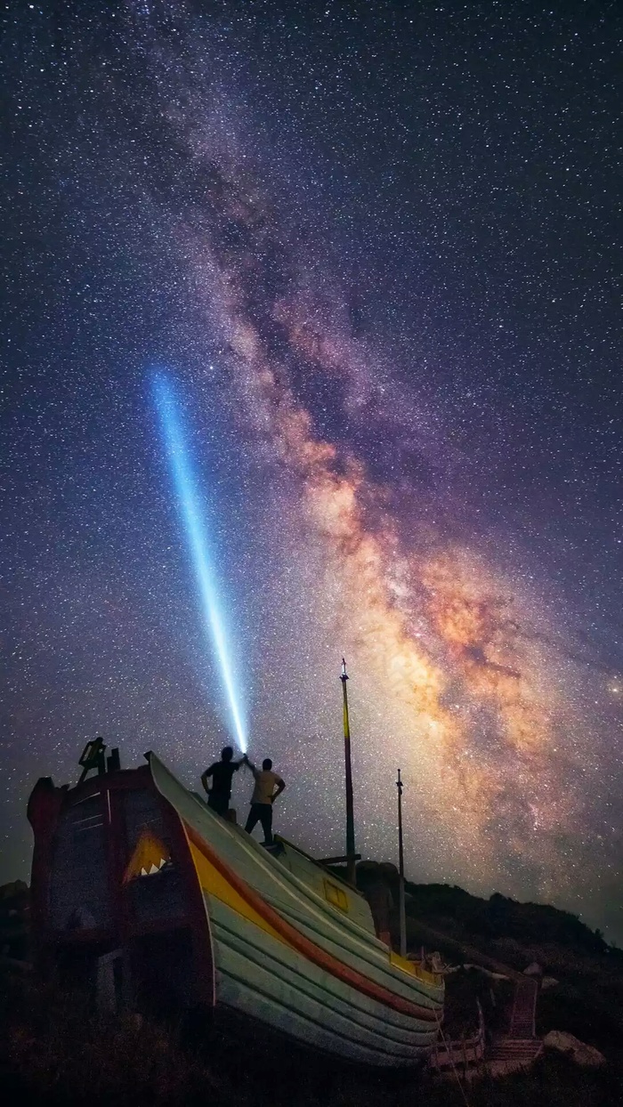 拿电筒照射星空的人高清摄影图片