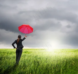 草地上打伞的职业女性图片