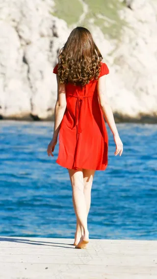 穿着红色裙子站在岸上的女人高清摄影图片