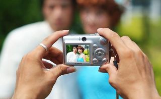 双手拿着相机拍照图片