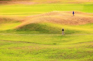 草地上打高尔夫球的运动人物图片