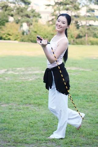 草地上跳绳的运动美女图片图片