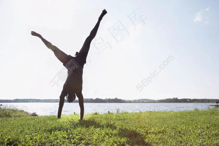 草地上倒立的男人摄影图片