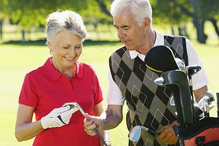 高尔夫球场上的老年夫妇高清图片