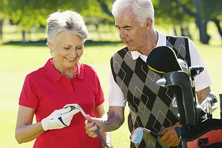 高尔夫球场上的老年夫妇高清图片