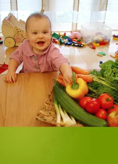 趴在桌子上拿蔬菜的小女孩图片