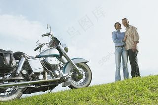 草地上的外国夫妇和摩托车图片