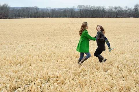 草地上嬉戏打闹的可爱女孩图片
