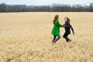 草地上嬉戏打闹的可爱女孩图片