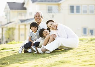 坐在草坪上开心的祖孙四人图片