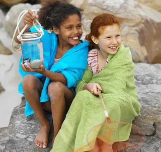 沙滩岩石上快乐的小女孩图片