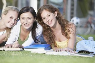 趴在草地上的女大学生图片