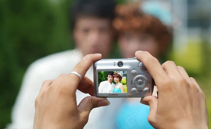 双手拿着相机拍照图片