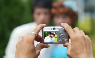 双手拿着相机拍照图片