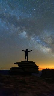 星空下站在石头上的人高清摄影图片