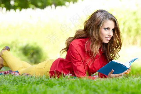 趴在草地上看书的外国美女图片