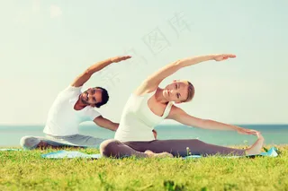 草地上练瑜伽的夫妻图片