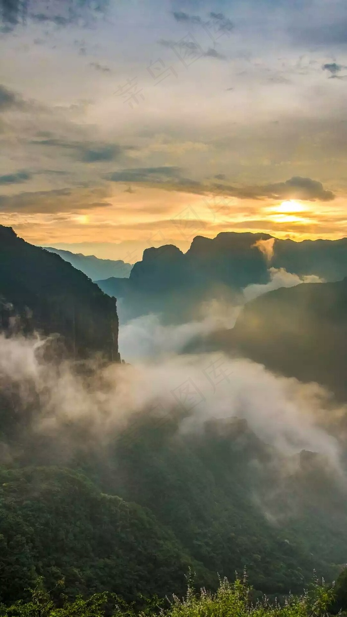 夕阳下云雾中的大山高清摄影图片