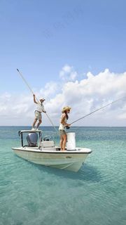 快艇上钩鱼的一对男女高清摄影图片