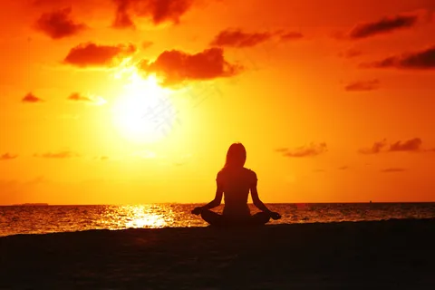 夕阳下坐在海边的美女 夕阳下坐在海边的美女