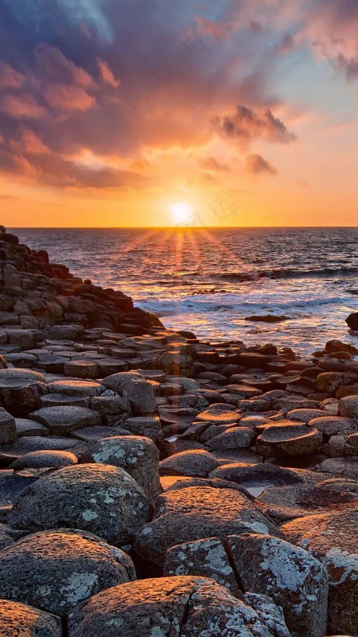 夕阳下的海岸防浪石高清摄影图片