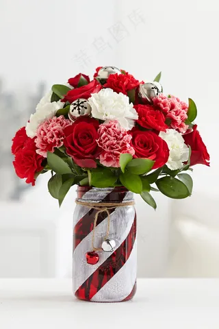 成品红色和白色彩绘玻璃梅森罐子中心花瓶，配以一束红玫瑰，粉色和白色康乃馨和叮当铃