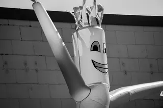 古怪的挥舞着充气手臂打气筒人