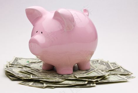 一堆一美元钞票上的粉红色小猪银行