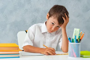 回到学校。快乐微笑的学生在书桌前画画。