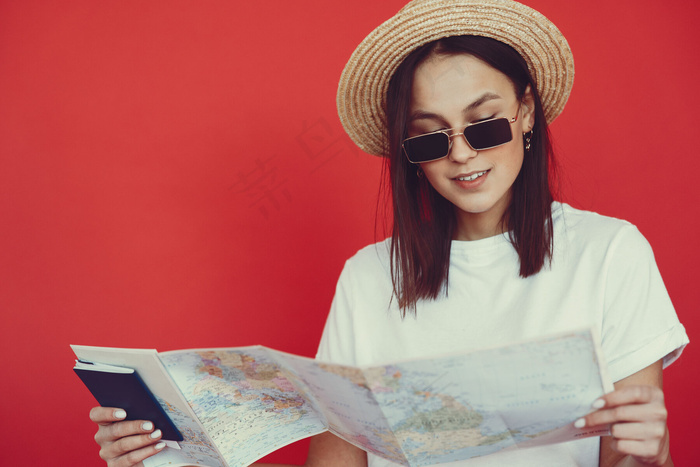 红墙上摆着旅游设备的时髦女孩