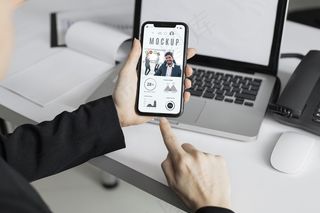 办公室里拿着智能手机模型样机的男人