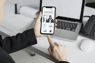 办公室里拿着智能手机模型样机的男人