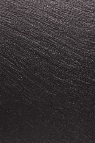 黑色石头，纹理为背景。平滑结构表面上的阴影和灯光