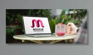 女自由职业者拿着一杯饮料放在桌上，手里拿着电脑模型样机