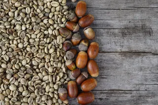 中间烤咖啡豆和橡子平放在木制背景上