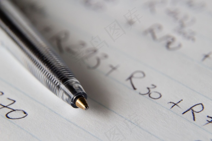 一张黑色钢笔在一张纸上的特写镜头，上面写着一些数字和代码