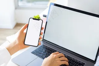 高角度的商务人士在笔记本电脑和智能手机上工作