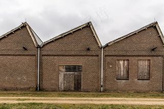 一座砖房附近的小路，天空阴云密布