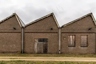 一座砖房附近的小路，天空阴云密布